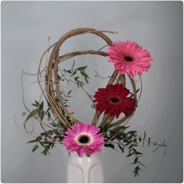 Arreglo de gerberas con detalles de bejuco y follaje con base de cerámica en forma de rostro - Image 2