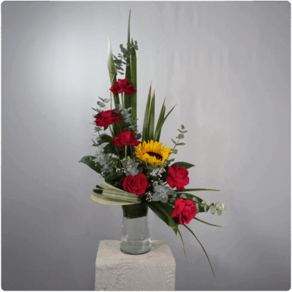 Arreglo de rosas, girasol, follaje con base de cristal