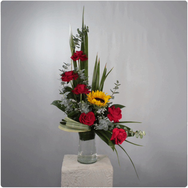 Arreglo de rosas, girasol, follaje con base de cristal
