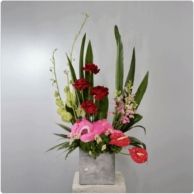 Arreglo floral de rosas, anturios, perritos, follaje + un peluche lotso con base de madera