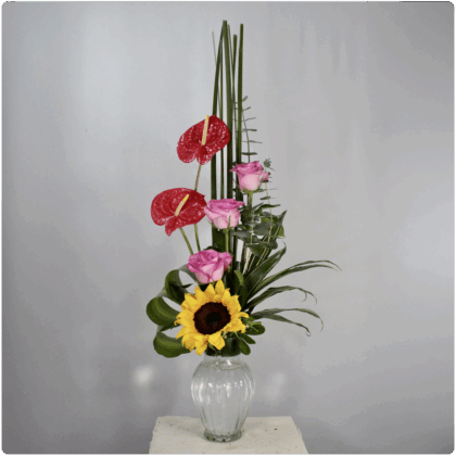 Arreglo floral de rosasanturio girasol follaje con base de cristal